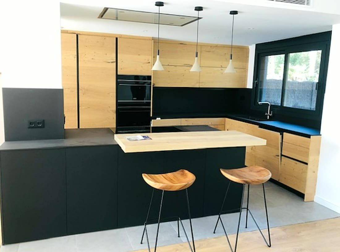 Cocina en negro mate y roble con barra y taburetes de madera